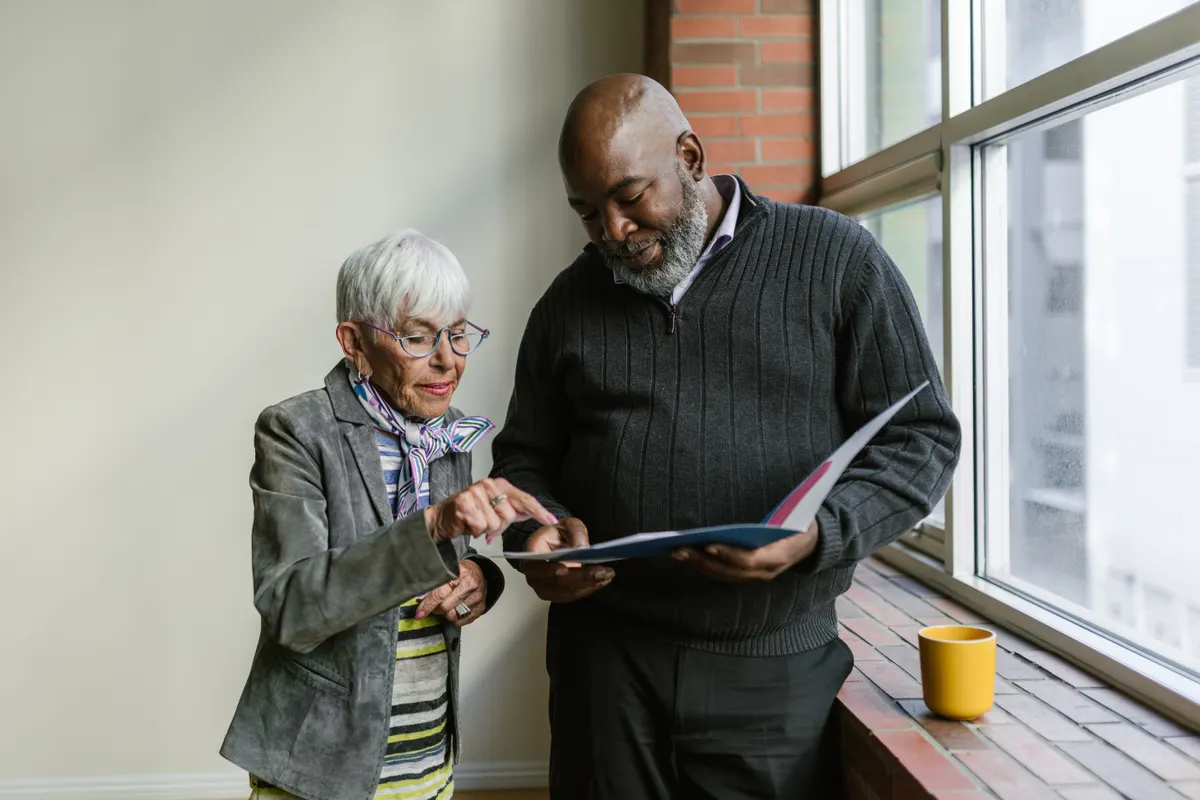Two adults discussing documents in a folder